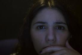 Close-up image of Maia Levy - subject of the documentary, THE VIEWING BOOTH - gazing intently into the camera.
